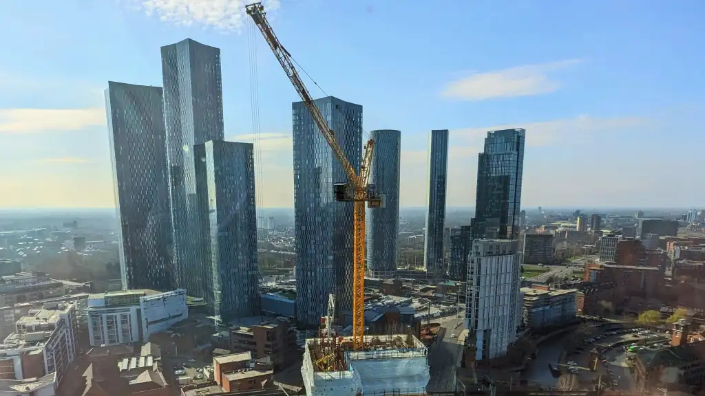 A photo from a hotel in Manchester, of a new tower construction nearby in the foreground with skyline in the background